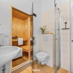 Badezimmer mit Dusche, Toilette und integrierter Sauna.