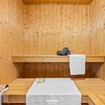 Sauna mit Holzwand, Bank und Handtuch