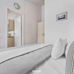 Schlafzimmer mit Bett, Kleiderschrank und Blick in die Küche.