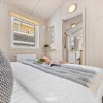 Schlafzimmer mit Bett, Fenster und Blick auf Außenbereich.