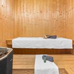 Sauna mit Holzwand, Liegefläche und Handtuch.