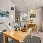 Wohn- und Essbereich mit Holzmöbeln, Sofa, Tisch und Fenster.