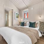 Schlafzimmer mit Bett, Fenster und angrenzender Dusche.