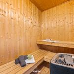 Sauna mit Holzwand, Bank und Steinkachel