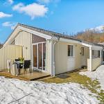 Wohnhaus mit Terrasse, Tisch und Stühlen. Schnee bedeckt den Boden.