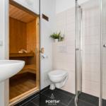 Badezimmer mit Dusche, Toilette und integrierter Sauna.