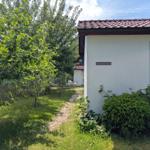 Haus mit Gartenweg, Bäumen und Straßenschild John-Brinekman-Straße 13.