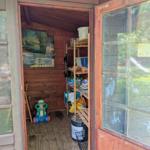 Holzvertäfelte Hütte mit Regal, Kinderwagen und Gemälde an der Wand.
