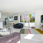 Living room with sofa, TV, and glass door to terrace