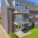 Modern multi-family house with balconies and terrace with garden.