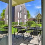 Terrace with table and chairs. View of garden and neighboring house.