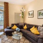Wohnzimmer mit braunem Sofa, gelben Kissen und Blick auf Balkon
