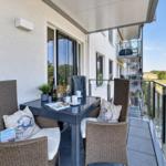 Terrasse mit Tisch, Stühlen und Sicht auf Grünland.