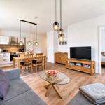 Apartment with kitchen, dining area, living room, and bedroom. Wooden furniture and TV.