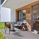 Terrace with table, chairs, and bench. Glass door leads into the interior.