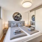 Schlafzimmer mit Doppelbett, Wandbild und integriertem Schrank.