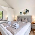 Schlafzimmer mit Doppelbett, Spiegelschrank und Wanddekoration.