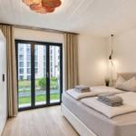 Schlafzimmer mit Doppelbett, Fenster und Holzboden.