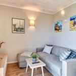 Wohnzimmer mit Sofa, Couchtisch und Wandbildern an den Wänden.