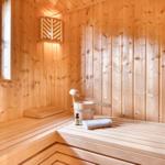 Sauna with wooden walls, bench, and bucket with ladle.