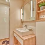 Badezimmer mit Dusche, Waschbecken und Spiegelschrank mit beleuchteten Spiegeln.