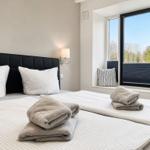 Bedroom with double bed, window, and towels.