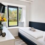 Bedroom with bed, window, and TV. Pillows are on the windowsill.