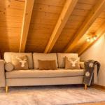 Ein Sofa mit Kissen und Decke unter Holzdecke mit Balken.