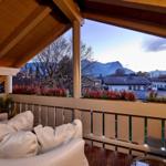 Terrasse mit Sitzgelegenheiten und Blick auf Berge und Dächer.