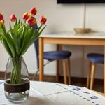 Auf dem Tisch steht eine Vase mit Tulpen. Im Hintergrund ist ein Esstisch mit Stühlen zu sehen.