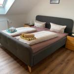 Schlafzimmer mit Doppelbett, zwei Nachttischen und Dachfenster.