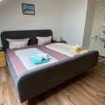 Schlafzimmer mit Doppelbett, Nachttischen und integriertem Bad mit Waschbecken.