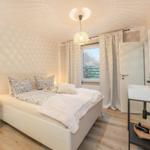 Bedroom with bed, nightstand, window, and sink.