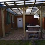 Terrace with pergola, grill, and umbrella. Backyard with brick paving and brick walls.
