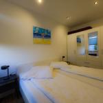 Bedroom with double bed, wardrobe, and wall art.
