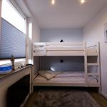 Room with bunk bed, window, and wall picture.