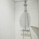 Duschkabine mit Duschbrause und Handbrause an Wand montiert