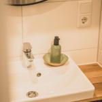 Waschbecken mit Spiegel, Seife und Steckdose