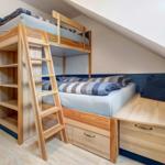 Doppelstockbett mit integriertem Schrank und Stauraum unterhalb des unteren Bettes.