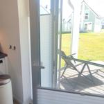 Kitchen with washing machine and view of terrace with lounge chair