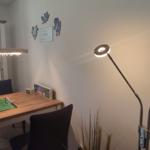 Dining area with table, chairs, and football table. Wall lighting and floor lamp.