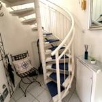 Wohnung mit Wendeltreppe, Stuhl und Spiegelfläche an der Wand.