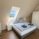 Schlafzimmer mit Doppelbett, Dachfenster und Kleiderschrank.