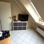 Schlafzimmer mit Dachschräge, TV, Schrank und Fenster