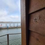 Blick vom Fenster auf den Hafen mit Steg und Wasser.