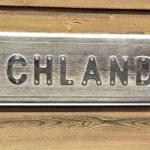 Holzschild mit der Aufschrift FISCHLAND an einer Holzwand