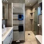 Badezimmer mit Dusche, Handtuchhalter und Waschtisch