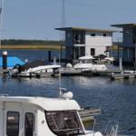 Hafen mit Booten und modernen Steghäusern an der Wasseroberfläche.
