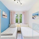 Zwei Einzelbetten, Fenster mit Vorhängen, Wandbild und Nachttisch.