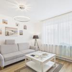 Wohnzimmer mit Sofa, Couchtisch und Wandbildern an der Wand.